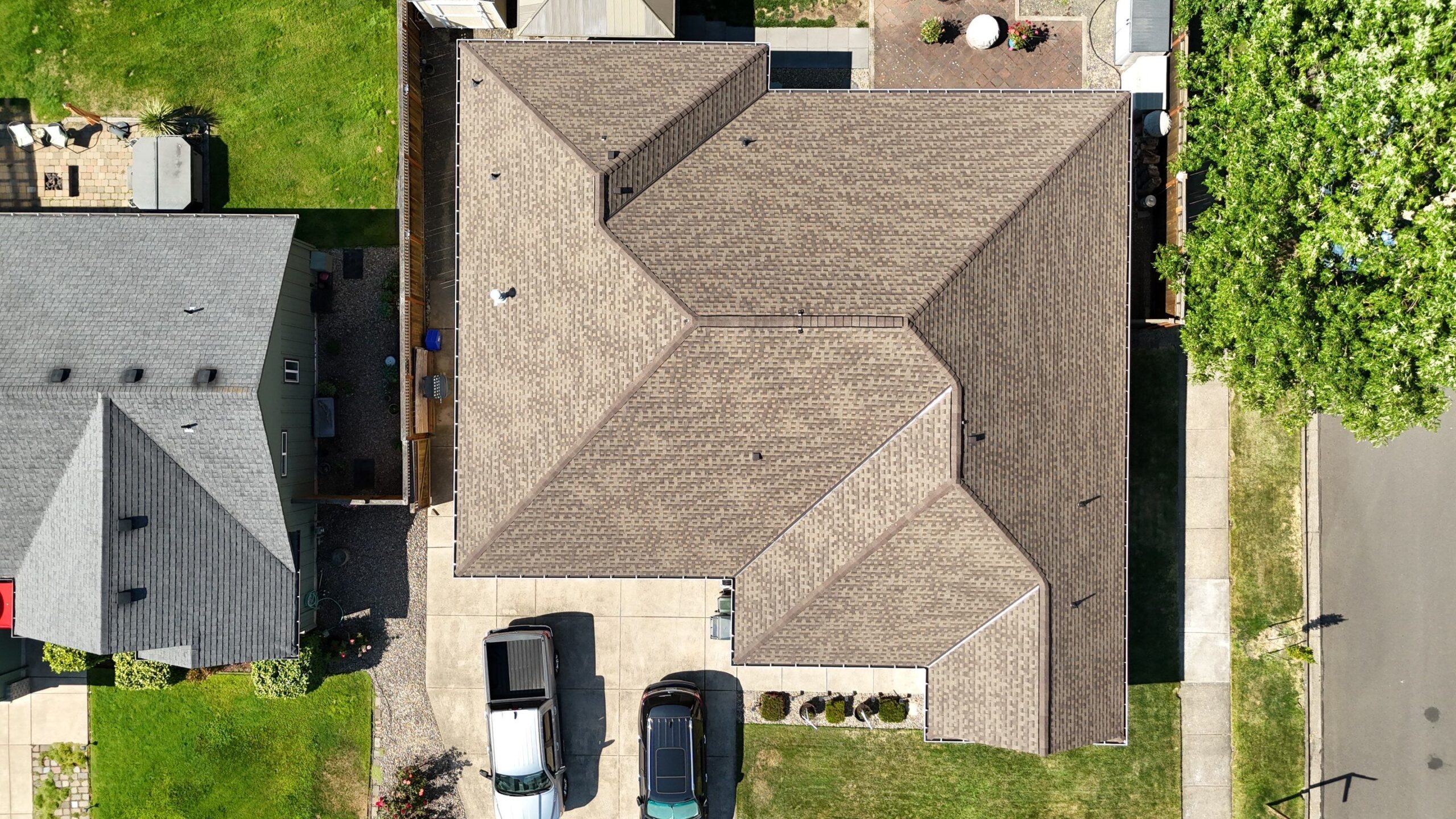 Homeowner receiving new shingle roof installation on older Cottage Grove house