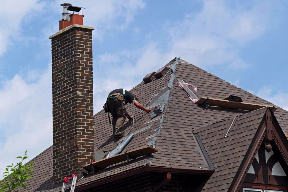 Roofing crew repairing wind-damaged roof on beachfront home in Florence, OR after severe coastal storm